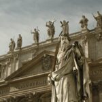 monument with statuettes on top building at daytime